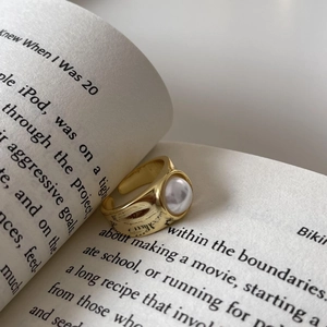 Vintage 18k gold plated S925 sterling silver open ring with pearl on a book background