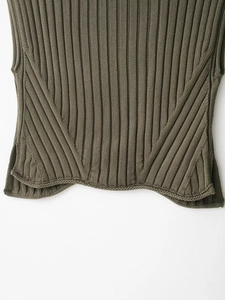 Close-up of olive green ribbed knit vest hem showing diagonal stitch pattern detail