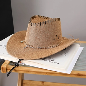 Detail of a brown woven cowboy hat with chain trim and adjustable chin strap