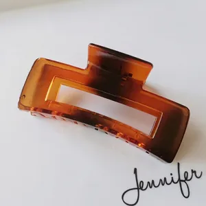 Detail view of large amber rectangle hair claw clip with shell pattern texture
