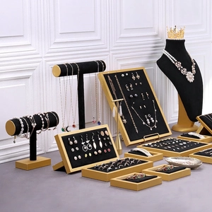 Black velvet and gold metal jewelry display set with necklace stands and earring trays