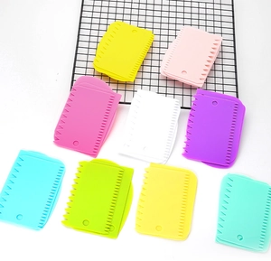 Detailed view of colorful plastic dough scrapers with jagged edges on a grid stand
