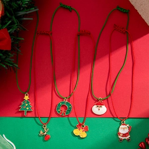 Detail of Christmas charms with enamel tree and reindeer on adjustable woven ropes
