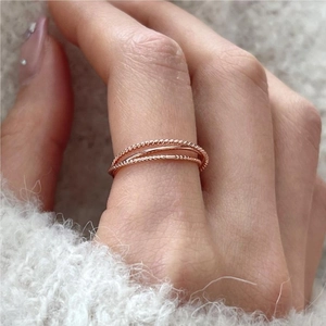 Detail view of three layered rose gold rings with twisted rope texture and minimalist style