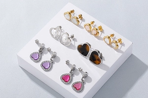 Macro shot of assorted heart-shaped earrings in gold and silver with rhinestones and pearls