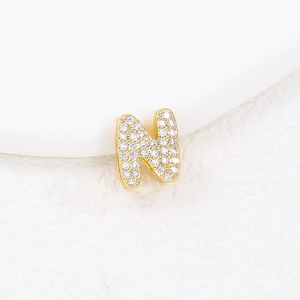 Macro detail of gold-plated bubble letter N pendant with micro-paved white cubic zirconia
