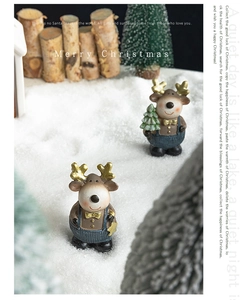 Close-up of resin Christmas reindeer figurines in a snowy forest festive tabletop scene