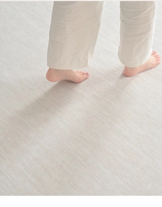 Detailed texture of cream waterproof rug with barefoot model showing soft comfort