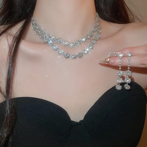 Detailed view of elegant double-layered floral necklace and drop earrings with crystals