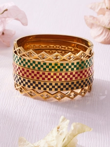 Detail of five-piece gold plated bracelet set featuring checkerboard enamel and zircons