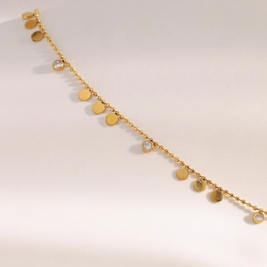 Détail de la chaîne à billes en acier doré 18K avec pendentif disque en zircon