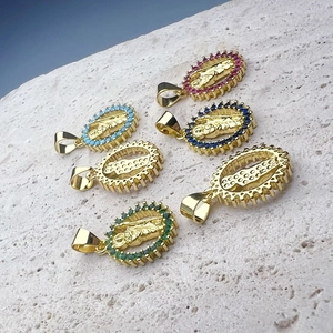 Golden Jesus pendants with colorful zircon stones on natural stone background