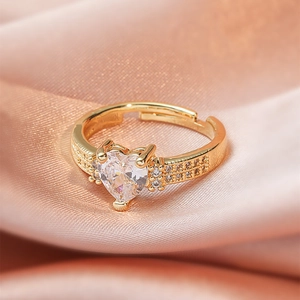 Macro shot of heart-shaped crystal ring with double row pave setting on gold band