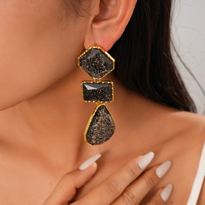 Gros plan de boucles d'oreilles géométriques en résine avec formes en losange