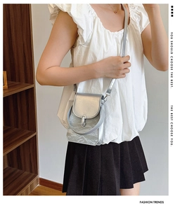 Fashionable silver crossbody bag with metallic texture shown on a stylish model
