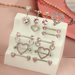 Pink heart-shaped zircon belly rings and nipple piercings on a white display stand