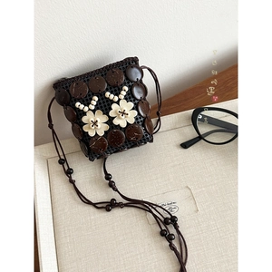 Detail of bohemian handmade mini crossbody bag with coconut shell and floral beadwork