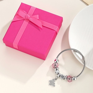 Detail of a silver crown charm bracelet with pink crystal beads and butterfly pendant