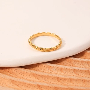 18k gold plated stainless steel ring with beaded scallop edge on a white ceramic plate