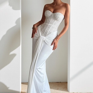 Detail of white sequined bodice and flowing floor-length fabric on evening gown