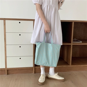Detalle de bolso tote de lona a cuadros azules y blancos con textura en un entorno cotidiano
