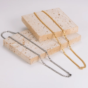 Polished gold and silver stainless steel NK chain necklaces on decorative stone blocks
