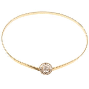 Détail macro d'une ceinture élastique dorée avec boucle ronde sertie de strass brillants