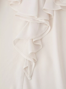 Detail of ruffled chiffon sleeves in cream white with flowing texture and elegant drape