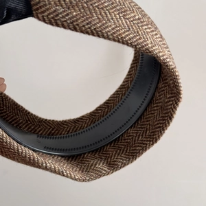 Detailed macro view of the brown herringbone wool texture and anti-slip plastic lining