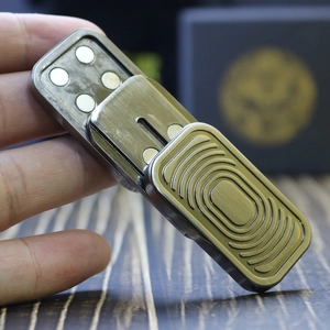 Macro shot of silver EDC slider with concentric rectangle texture and magnetic surface