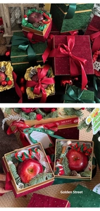 Detailed Christmas apple gift boxes in red and green velvet with festive ribbons and pine cones