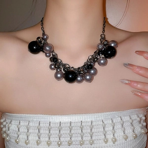 Detailed close-up of dark gothic pearl tassel necklace with metallic chain layers