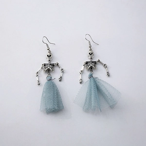 Macro detail of silver skeleton earrings with light blue mesh skirt on a white background