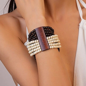 Vue macro d'un bracelet multicouche perlé avec coque de noix de coco et plaque en bois