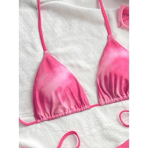 Close-up of tie-dye pink gradient bikini top with ruched triangles and sunglasses
