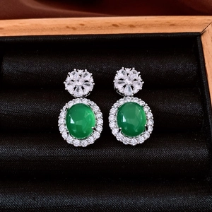 Detailed view of oval green chalcedony earrings with zircon inlay on black velvet base