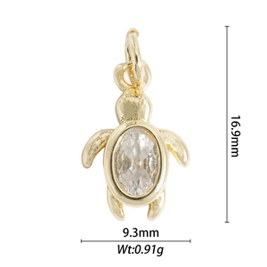 Detailed view of a gold turtle pendant with crystal inlay showing 16.9mm by 9.3mm dimensions