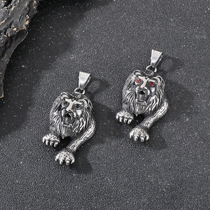 Detailed macro view of silver lion head pendants with red gem eyes in embossed 3D design