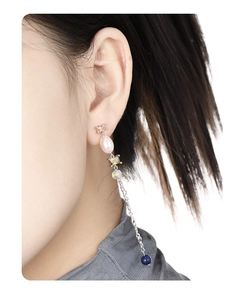 Detail shot of asymmetric 925 silver fringe earrings with baroque pearls and colorful zircons