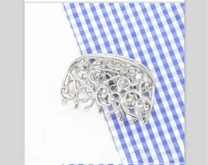 Macro detail of a vintage silver hollow butterfly hair claw clip with intricate floral patterns
