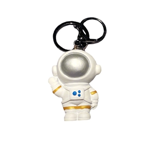 Portachiavi a forma di astronauta in resina con dettagli in oro e nero.