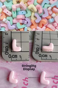 Macro view of colorful resin letter L beads showing hole design and 1cm scale detail