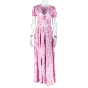 Détail de robe longue à fleurs roses avec col en V et manches bouffantes sur fond blanc
