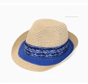 Detail of summer straw sun hat with blue patterned band and contrast trim