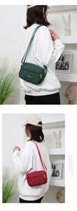 Detail view of quilted nylon crossbody bags in forest green and wine red with adjustable straps