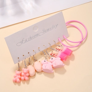 Détail d'un ensemble de boucles d'oreilles roses avec breloques en résine sur carte