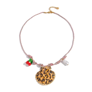 Detail of bohemian woven necklace with leopard shell pendant and cherry beads
