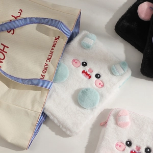 Detailed view of the soft white plush cartoon pig tablet sleeve with pink embroidery