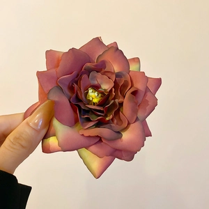 Macro detail of the layered vintage pink fabric rose on a sweet spring hair clip