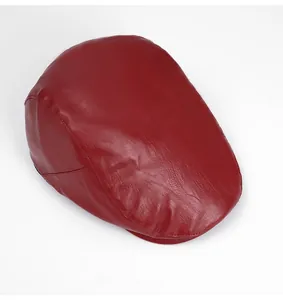 Dettaglio dall'alto della coppola in pelle PU rossa con trama fine e cuciture curate